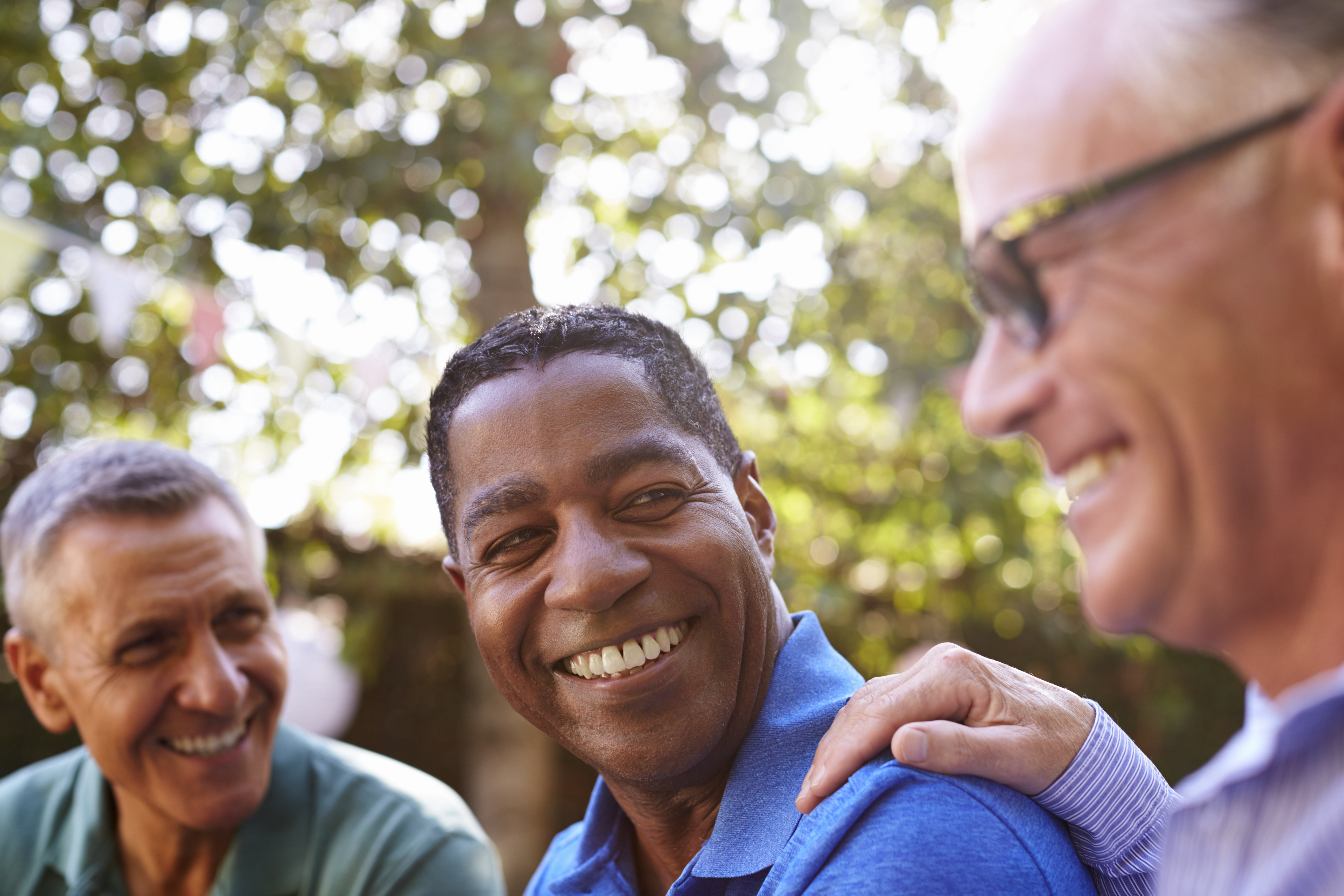 Mature Male Friends Socializing In Backyard Together
